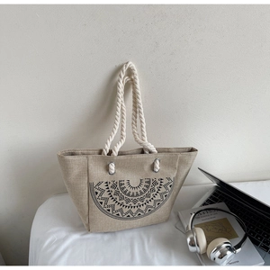 Detail of beige linen bucket tote bag with black geometric print and thick cotton rope handle