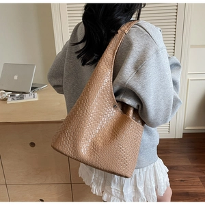 Detail of a brown woven leather hobo shoulder bag showcasing the intricate textured pattern