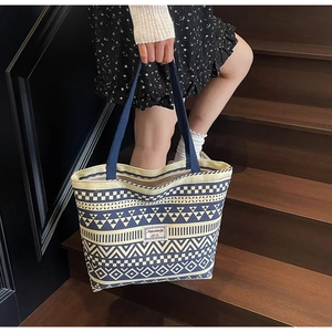 Close-up of canvas tote bag with blue geometric ethnic patterns and brand patch