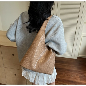 Detail shot of the khaki woven tote bag showing the textured material on the shoulder