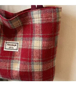 Close-up of red and white plaid tote bag featuring soft woolen texture and fabric label