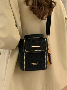 Leopard print crossbody bag with gold rivet detailing and beaded charm accessory
