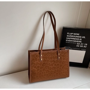 Detail of the high-capacity leopard print tote bag with brown suede texture and slim straps