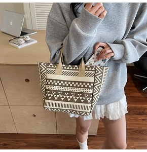 Detail of bohemian geometric pattern on beige canvas tote bag with brown fabric handle
