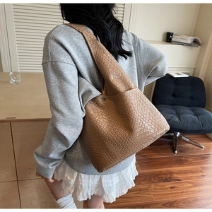 Close-up of brown woven leather texture on a large capacity stylish tote bag