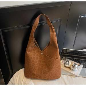 Close-up of leopard print tote bag with soft suede texture and metallic buckle detail