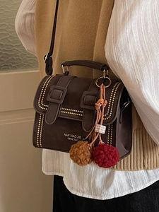Braune Vintage-Umhängetasche mit goldenen Nieten und weichem Plüschball-Anhänger