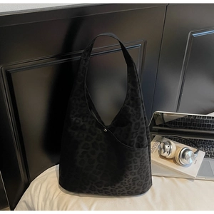 Detail of black leopard print hobo tote bag in premium matte suede with metal snap closure