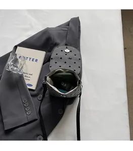Internal view of grey felt polka dot crossbody bag holding a phone and perfume