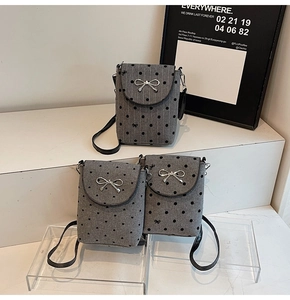 Detail of gray textured mini crossbody bags featuring patterns and silver bow buckles