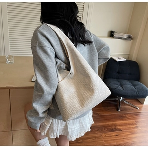 Close-up of white woven leather texture on a large capacity hobo shoulder bag for women