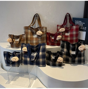Variety of plaid canvas tote bags in different sizes with cute sheep charms on a display