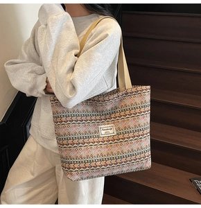Close-up of geometric pattern canvas tote bag showing colorful tribal embroidery textures