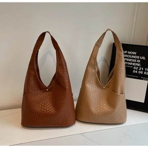 Detail of large woven tote bags in brown and khaki with magnetic metal closure
