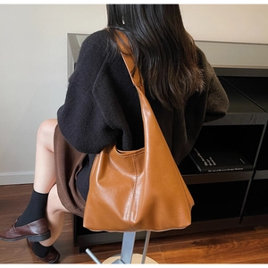 Close-up of brown oversized tote bag showing premium leather texture and minimalist design