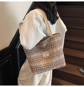 Detailed shot of ethnic geometric pattern tote bag with woven shoulder strap and logo label