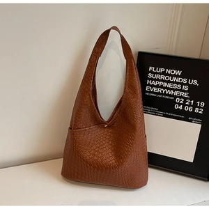 Detailed close-up of brown woven texture and metal buckle on the stylish hobo tote bag
