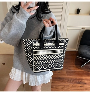 Canvas tote bag with black and white geometric ethnic patterns held by a model