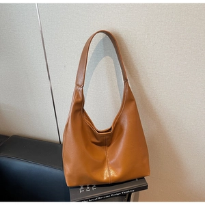 Macro shot of textured caramel leather material and wide strap on this tote bag