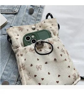Detail of off-white corduroy phone bag showing interior storage capacity and front pocket