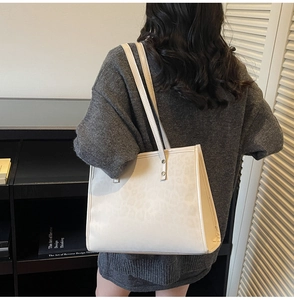 Lifestyle view of large leopard print tote bag worn as a chic off-white shoulder bag