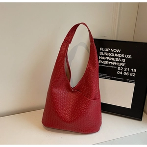Macro shot of red faux crocodile leather texture and side pocket on hobo tote bag