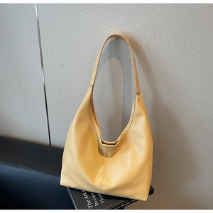 Detail of light yellow hobo bag featuring premium lychee grain leather and wide strap