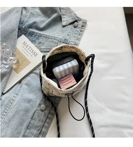 Top view of open corduroy mini bucket bag showing interior space and striped strap