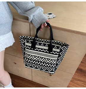 Detail of canvas tote bag featuring geometric patterns like checkerboard and zig-zag waves
