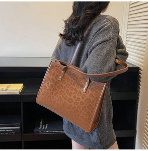 Detail of leopard print tote bag featuring metallic rivets and slim leather shoulder straps