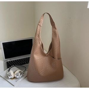 Macro view of brown woven texture and snakeskin pattern on a large leather tote bag