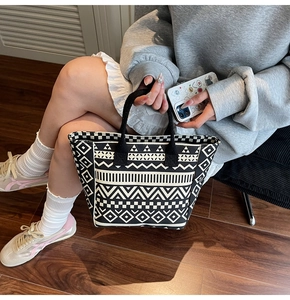 Close-up of geometric ethnic pattern on a durable canvas tote bag with black handles