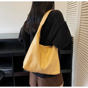 Detail of yellow PU leather tote bag showing vertical stitching and soft grainy texture