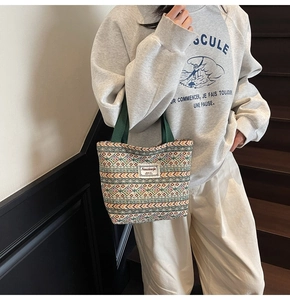 Ethnic style canvas tote with geometric weaving and sturdy green handles in lifestyle view