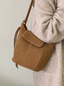 Caramel minimalist bucket bag with white contrast stitching and matte leather finish