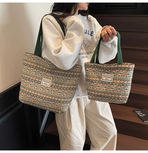 Detailed view of the ethnic woven tote bag with green canvas handles on model