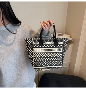 Detailed view of canvas tote bag with black and white geometric tribal patterns