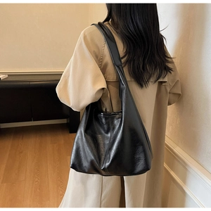 Detail of black pebbled PU leather hobo bag showing texture and wide shoulder strap
