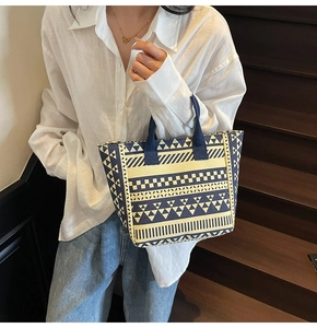 Close-up of geometric pattern canvas tote bag with navy blue woven handles