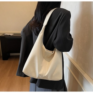 Detail of soft beige hobo bag with pleated leather texture and wide shoulder strap
