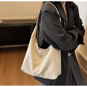 Hobo style cream tote bag detail on model showing soft pleated leather texture and size