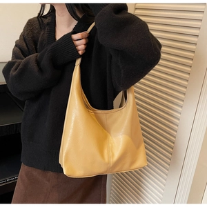 Detailed close-up of a large beige faux leather hobo bag with textured stitching details