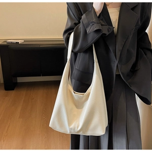 Detail of white PU leather tote bag with vertical stitching and smooth pebble texture