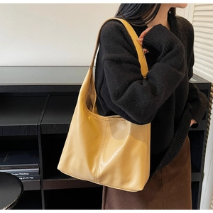 Detailed texture of beige PU leather on a large Hobo bag with minimalist vertical stitching