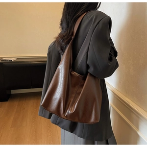 Detail view of large dark brown hobo shoulder bag with a textured leather finish