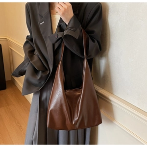 Close-up of deep brown hobo tote bag with textured synthetic leather and a large shoulder strap