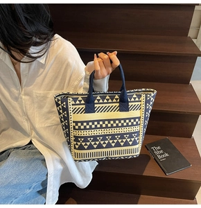 Close-up of canvas tote bag with blue geometric patterns on a wooden staircase
