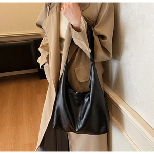 Detailed view of black large capacity tote bag featuring glossy crinkled leather texture
