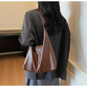 Rear view of brown faux leather tote bag showing large capacity and half-moon silhouette