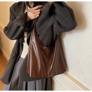 Detailed texture of dark brown faux leather tote with elegant vertical stitching